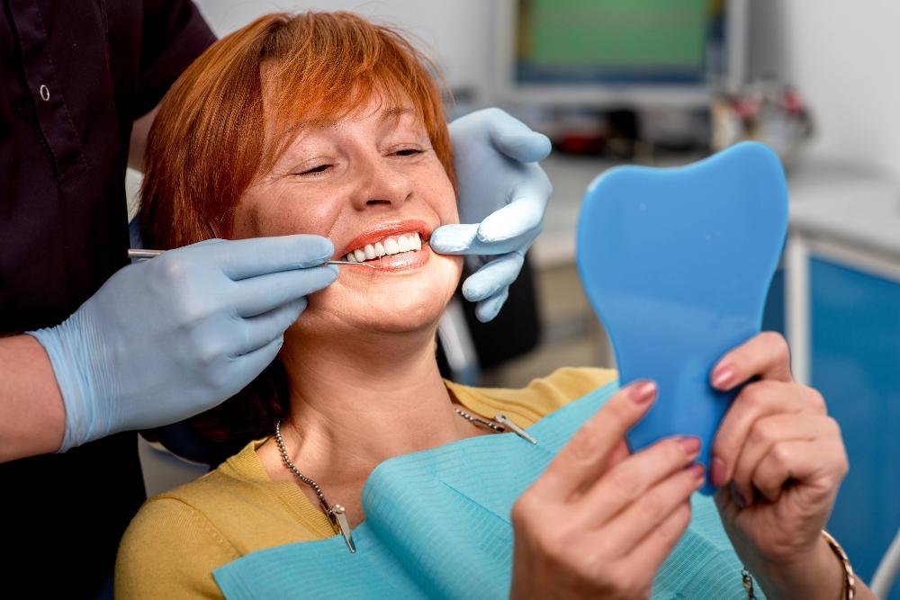 woman in a dental chair while looking at mirror