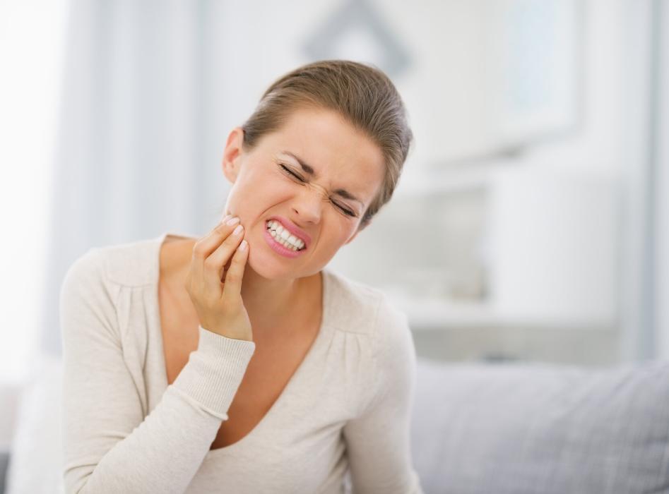 woman holding jaw from pain
