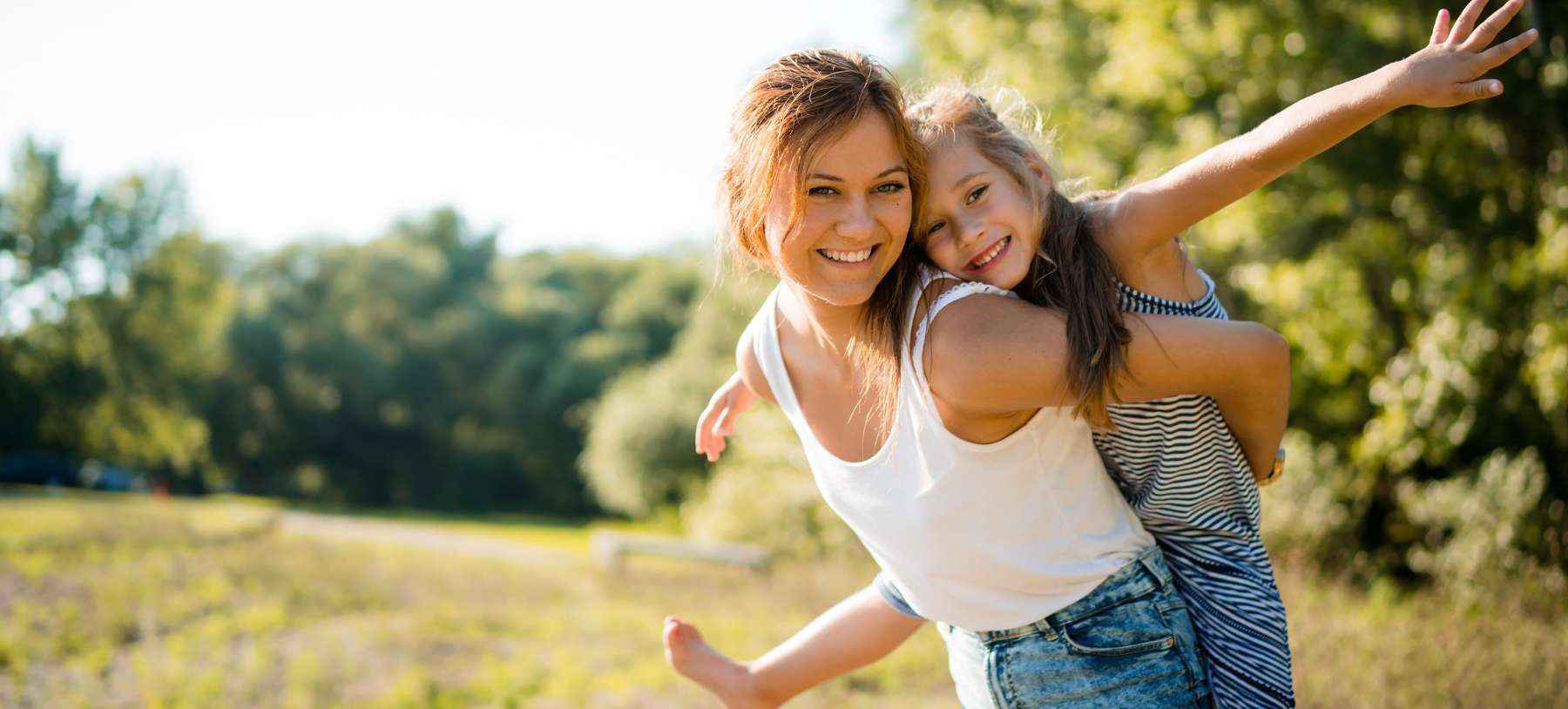 kids dentist arvada | Woman giving a girl a ride on her back