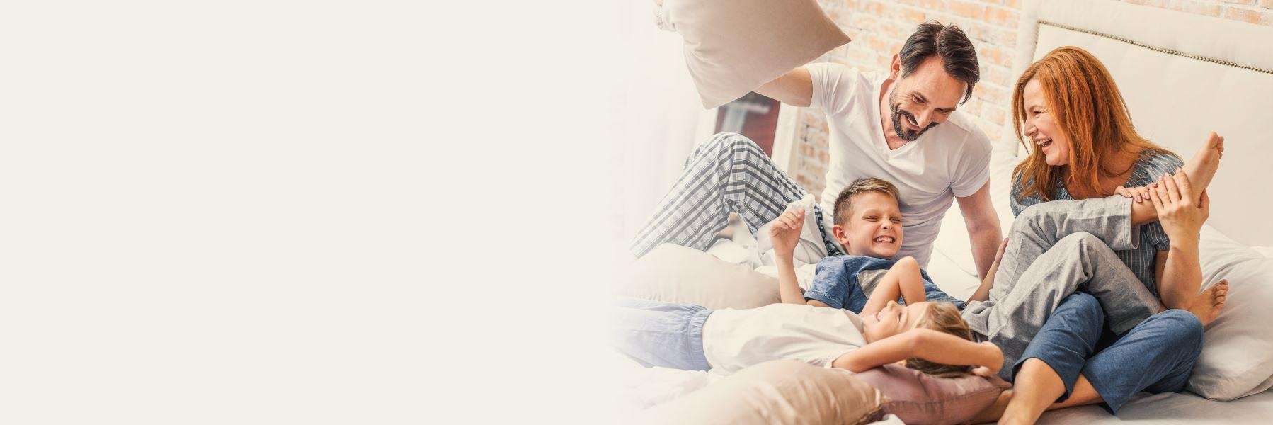 family dentist arvada | A family laughing in bed