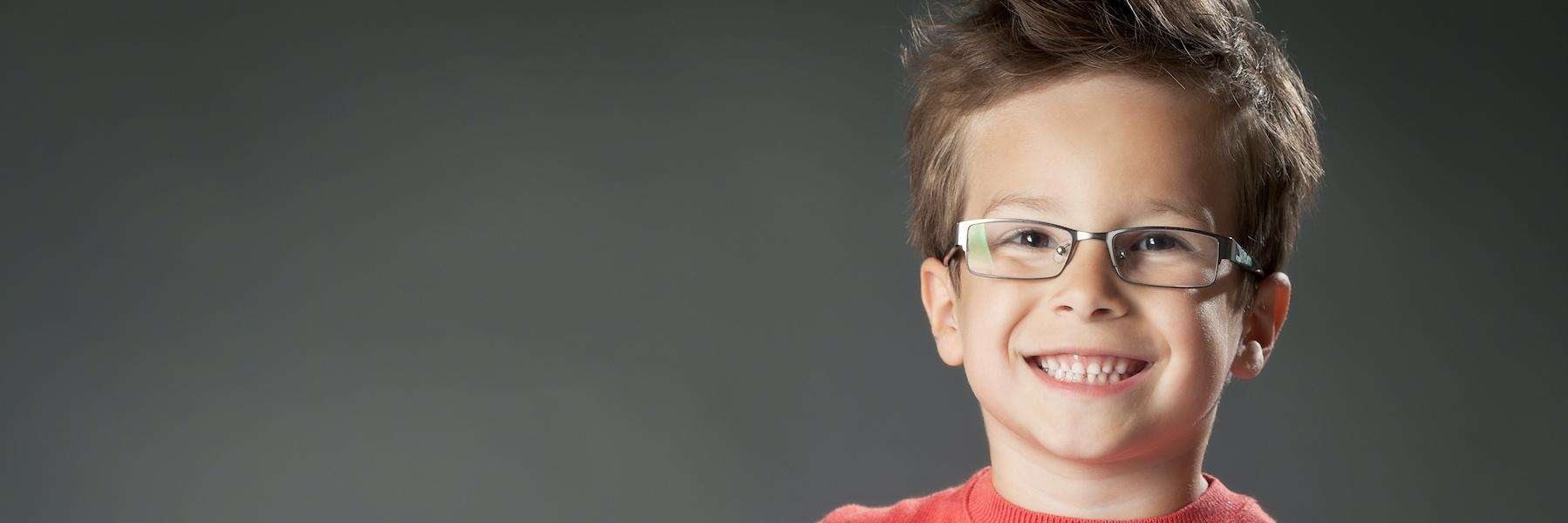 Children's dentistry Arvada | A smiling child with glasses