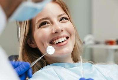 Woman smiling during a dental exam | Arvada Dentist